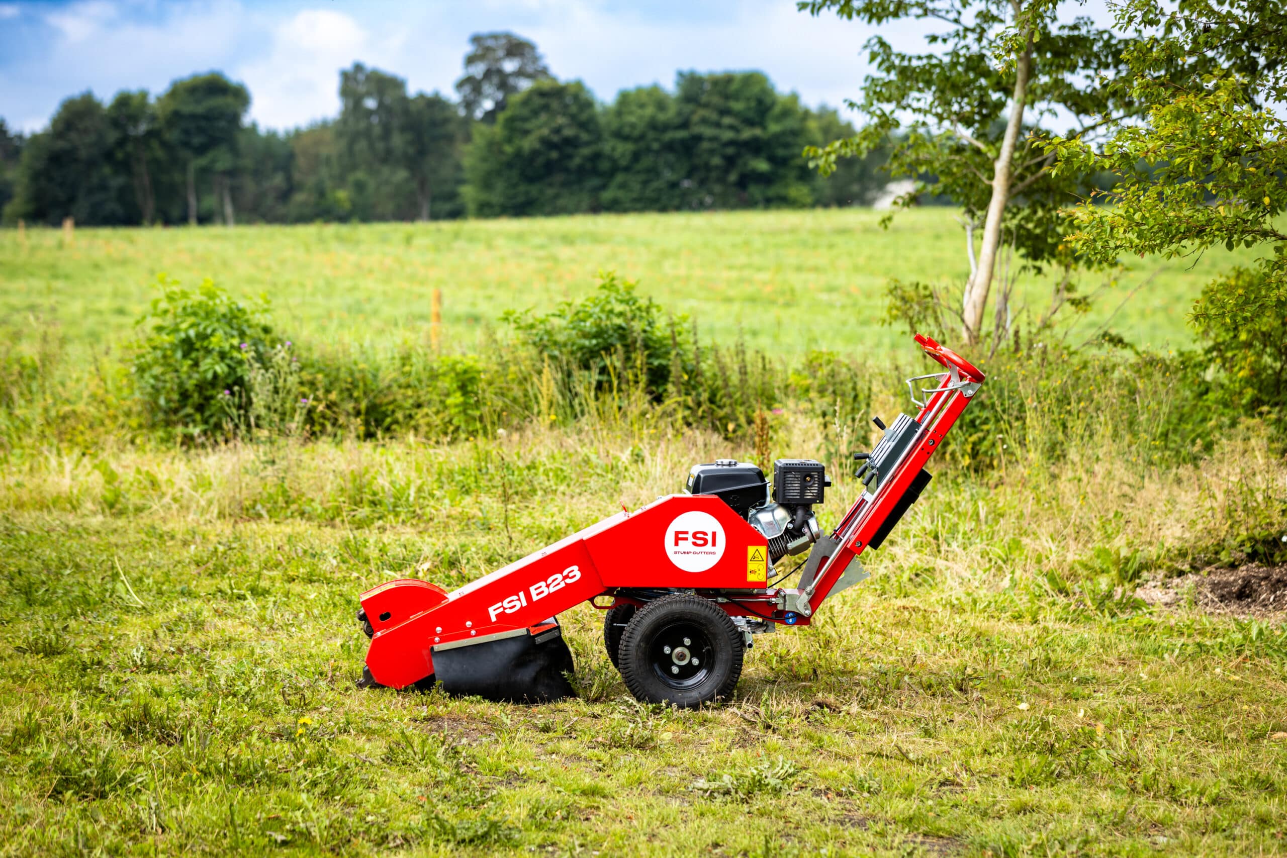 FSI B23 pedestrian stump grinder positioned in a field ready for operation