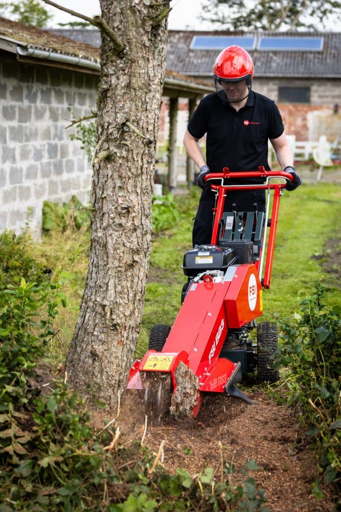 Operator using FSI B23 stump grinder to remove a tree stump
