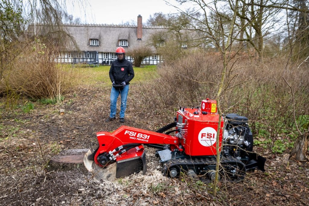 Operator using FSI B31-980 Remote stump grinder via wireless remote control at safe distance